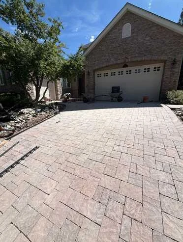 Wide decorative patterned driveway leading to a residential garage.